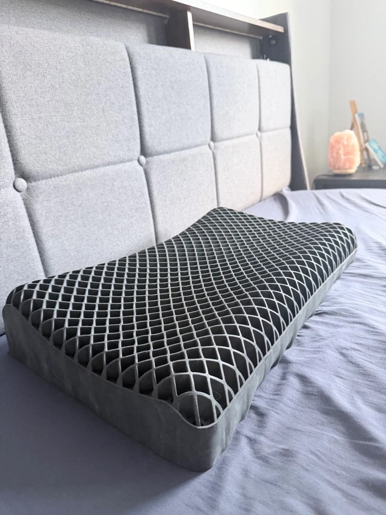 Customer holding Latticore pillow on a bed